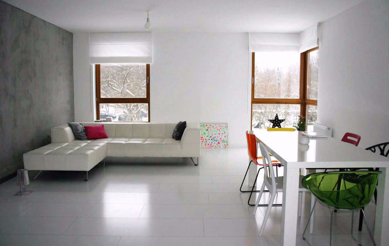 Białe rolety rzymskie w nowoczesnym minimalistycznym salonie